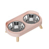 A pink pet feeding dish with two stainless steel bowls for dogs and cats.
