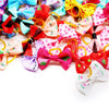 A colorful assortment of 200 handmade fabric bows in various patterns and colors for dogs and cats