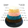 A stack of round, fluffy pet beds in various colors and sizes, showing a diameter scale for different pet weights.