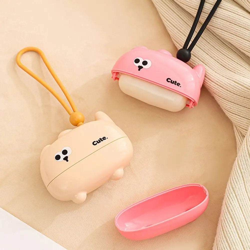 Pink and beige reusable pet hair roller with a cute cartoon design and attached string.