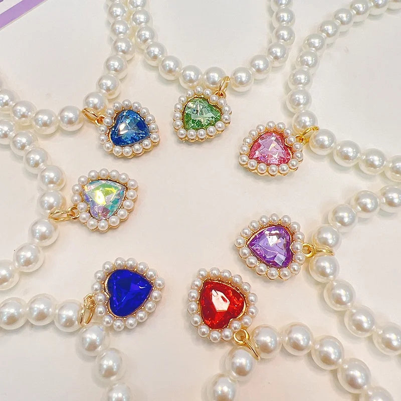 A collection of pearl necklaces featuring colorful gemstone pendants for pets.