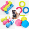 Assortment of colorful squeaky chew toys for dogs including rubber toys and a dog head shape.