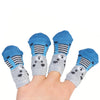 A hand is holding four pairs of anti-scratch cotton pet socks for small dogs and cats featuring blue, gray, and black stripes