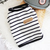 A black and white striped sleeveless vest for a small dog or cat is displayed on a white surface.