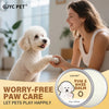 A woman is applying Shea Butter Pet Paw Balm to a white poodle puppy's paw.