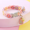 Buntes Halsband für Hunde und Kätzchen mit Sicherheitsglocke in rosa, orange und lila floralen Texturen.