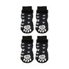 A pair of black breathable anti-slip dog socks featuring white paw print designs.
