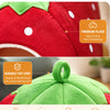 A red strawberry-shaped plush rabbit bed and hay feeder set with a green top loop.