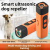 An orange and black portable ultrasonic dog repellent device is shown next to a dog.