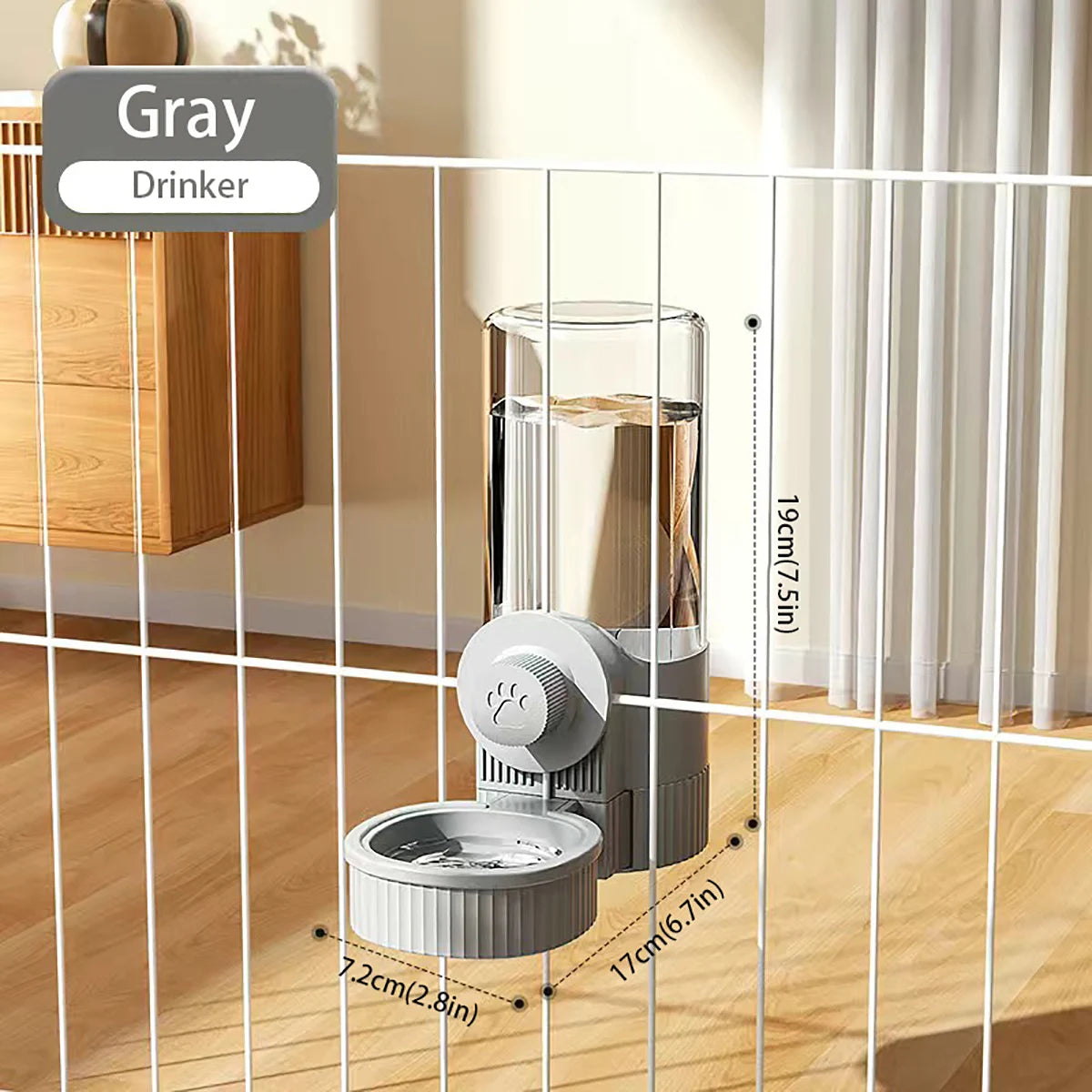 Un bol de mangeoire automatique pour animaux gris à gravité, à l'intérieur d'une cage en fil blanc, à côté d'un meuble en boi