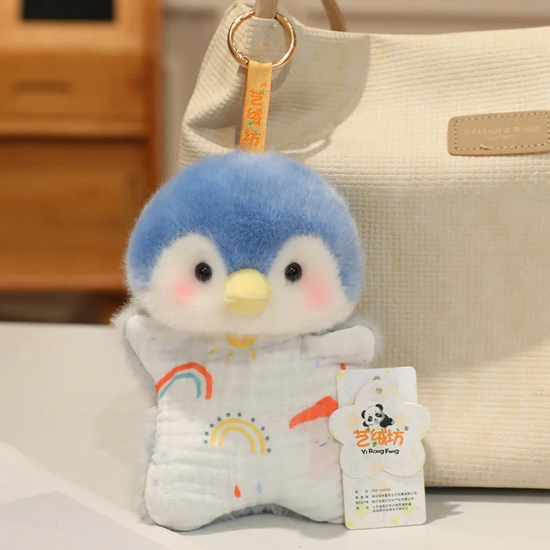 A small, soft blue and white cartoon penguin bean bag plush toy is displayed next to a beige canvas bag.