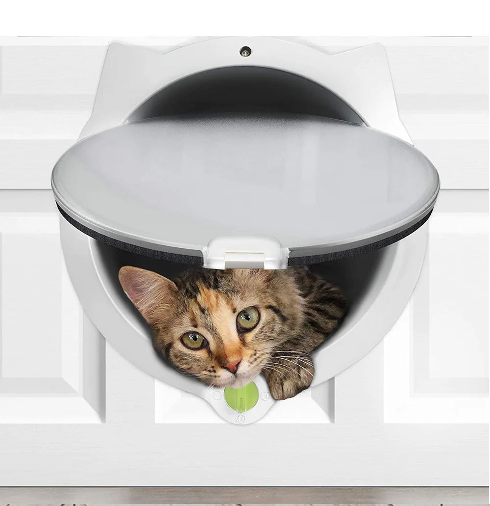 Un chat tigré gris regarde par l'ouverture d'une porte d'animal blanche installée dans un meuble blanc.