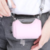 Rosa tragbare Tiertasche mit grauem Riemen, auf dunkelblaue Jeans gelegt.