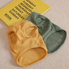 A yellow knitted pet shirt for a dog or cat lies next to a green knitted shirt and a yellow calendar book.