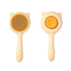 A light beige pet deshedding brush for cats and dogs with an orange bristled head.