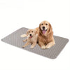A golden retriever puppy lying on a gray reusable pet training pad.