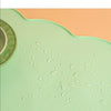 A light green silicone pet feeding mat with water droplets on its surface.