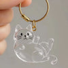 A clear silicone cat charm attached to a gold-colored keychain ring.
