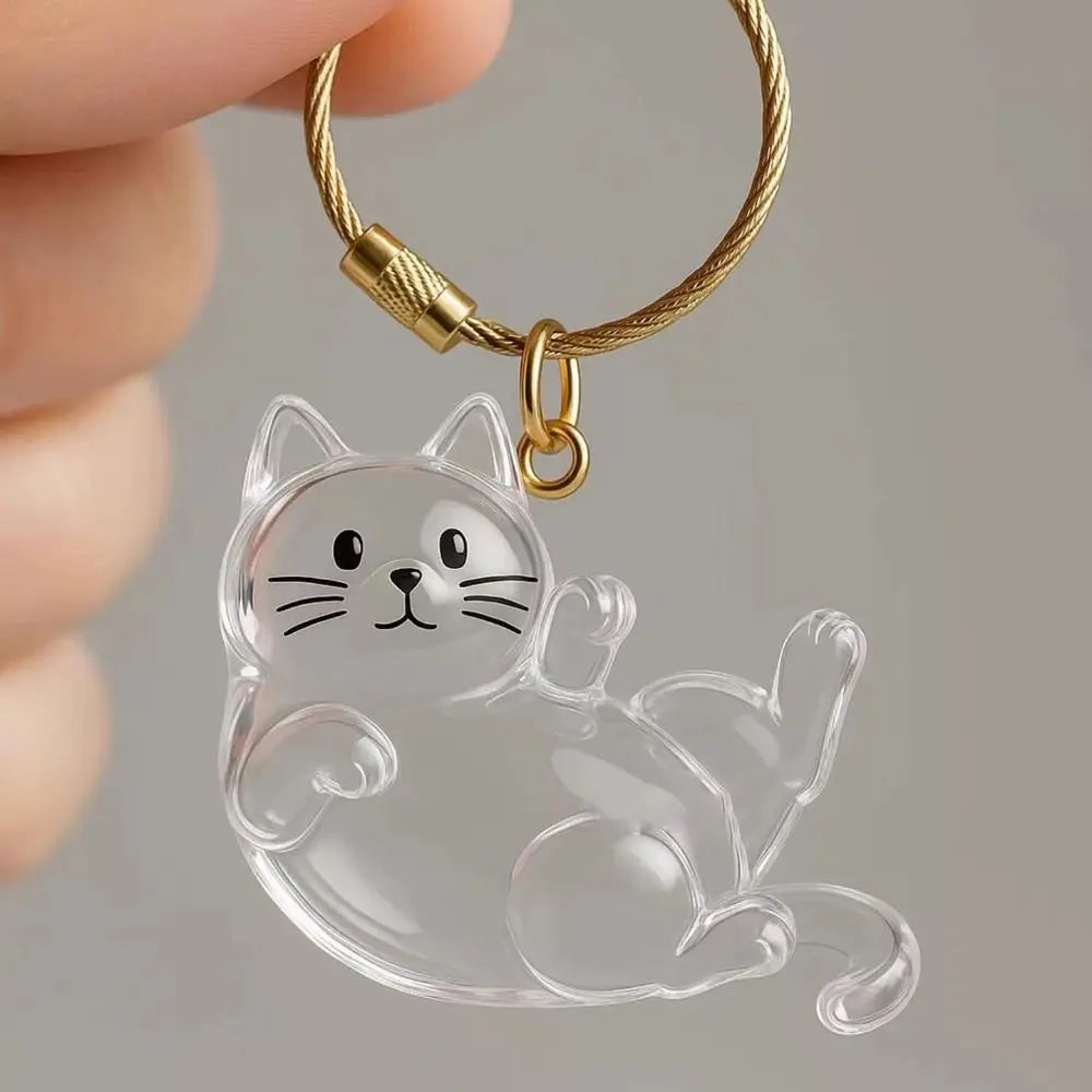 A clear silicone cat charm attached to a gold-colored keychain ring.