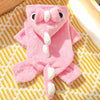 A pink fleece dog hoodie with animal ears lying on a yellow striped fabric.