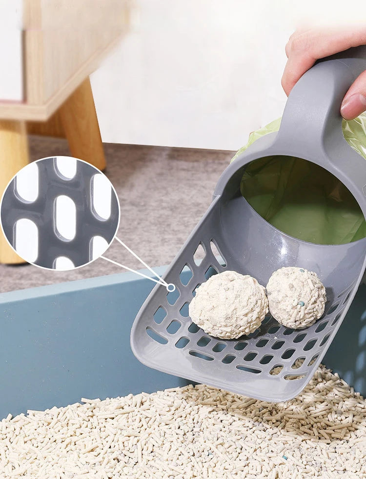 A gray reusable pet litter scoop is shown with a small white waste bag and loose litter on a beige surface.