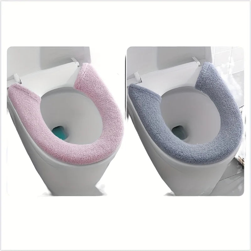 A pair of plush non-slip toilet seat covers in pink and gray are shown inside a toilet bowl.