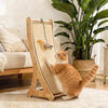 Eine orange tabby Katze spielt auf einem vertikalen Sisal-Kratzbaum mit Holzständer drinnen.