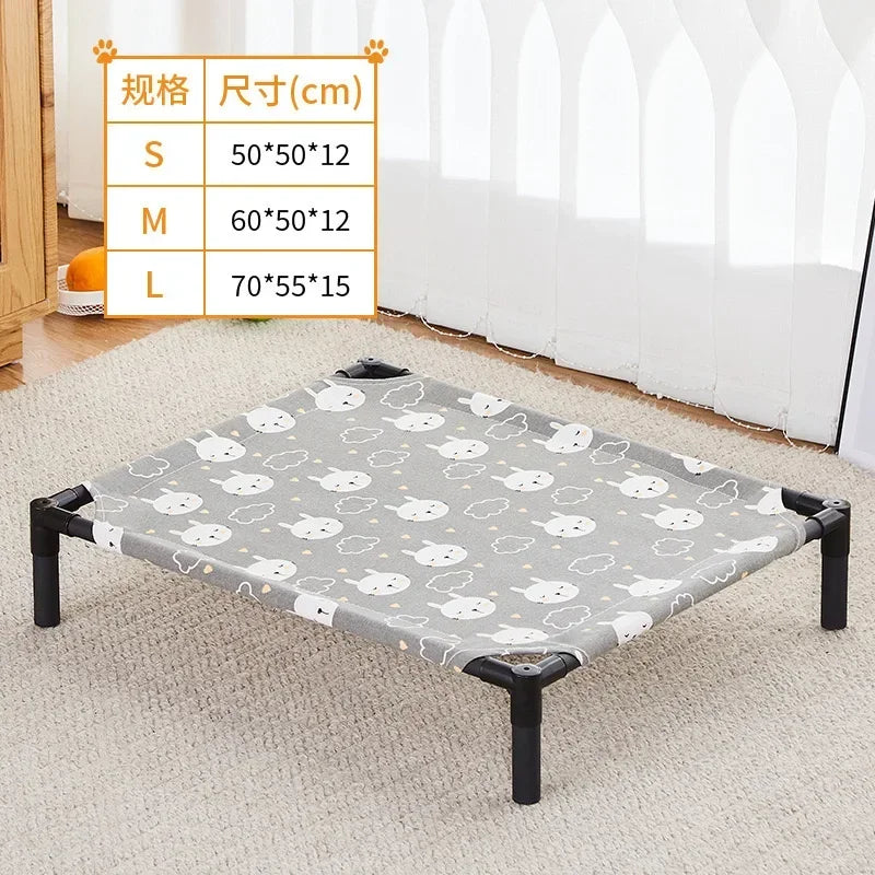 A gray portable folding pet bed with a removable cover is displayed on a light carpet.