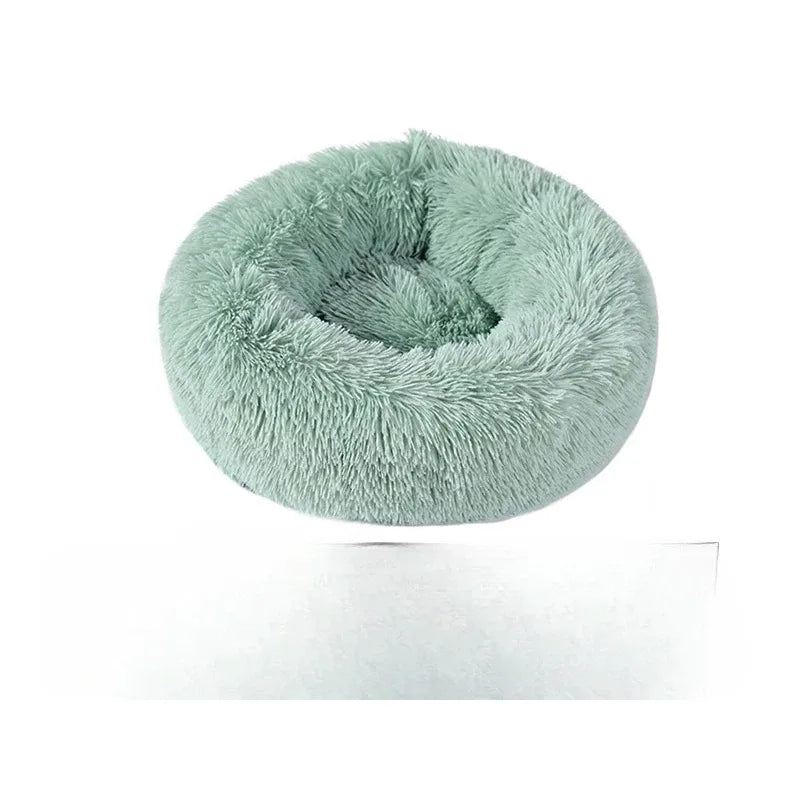 A round, fluffy teal faux fur pet bed for cats and dogs.