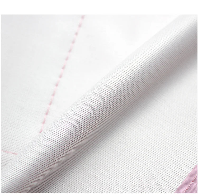 Close-up of a white waterproof reflective dog raincoat fabric showing a seam and texture.