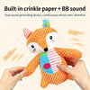 An orange plush dog toy with crinkle paper and a BB sound is being held by a hand.