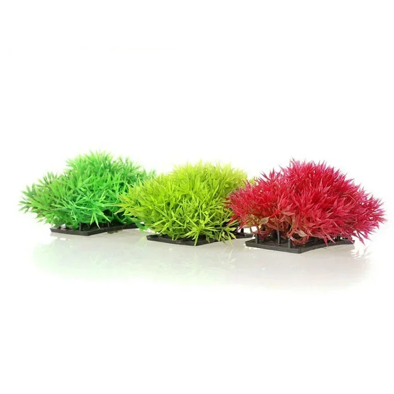 Three vibrant artificial aquarium plants in shades of green and red displayed on a black base.