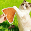 A cat is interacting with an orange natural loofah cat chew toy in the grass.