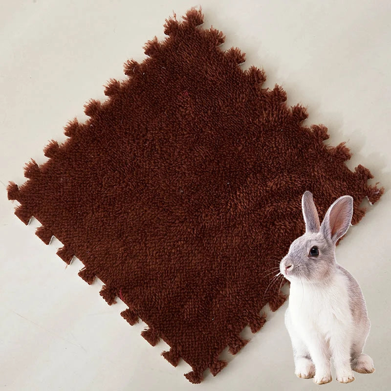 A small gray rabbit sitting on a dark brown, fluffy fleece pet warming mat.