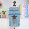 A light blue denim jacket shaped like a vintage suitcase with a gold-colored handle and a silver star decoration.
