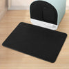 A black double-layer cat litter mat is shown in front of a light green and black litter box.