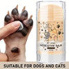 A hand is applying pet stick nose and paw balm for dogs and cats onto a cat's paw.
