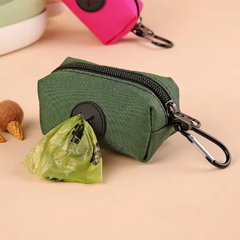 Pochette à fermeture éclair vert foncé avec un mousquet noir, à côté d'un sac plastique vert froissé.
