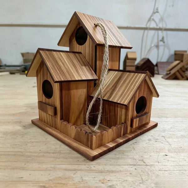 A rustic wooden bird house made of light brown wood with a pitched roof and a natural twine hanging from the entrance.