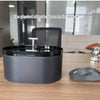 Un bol de fontaine à eau automatique pour chat gris foncé sur une table en bois.