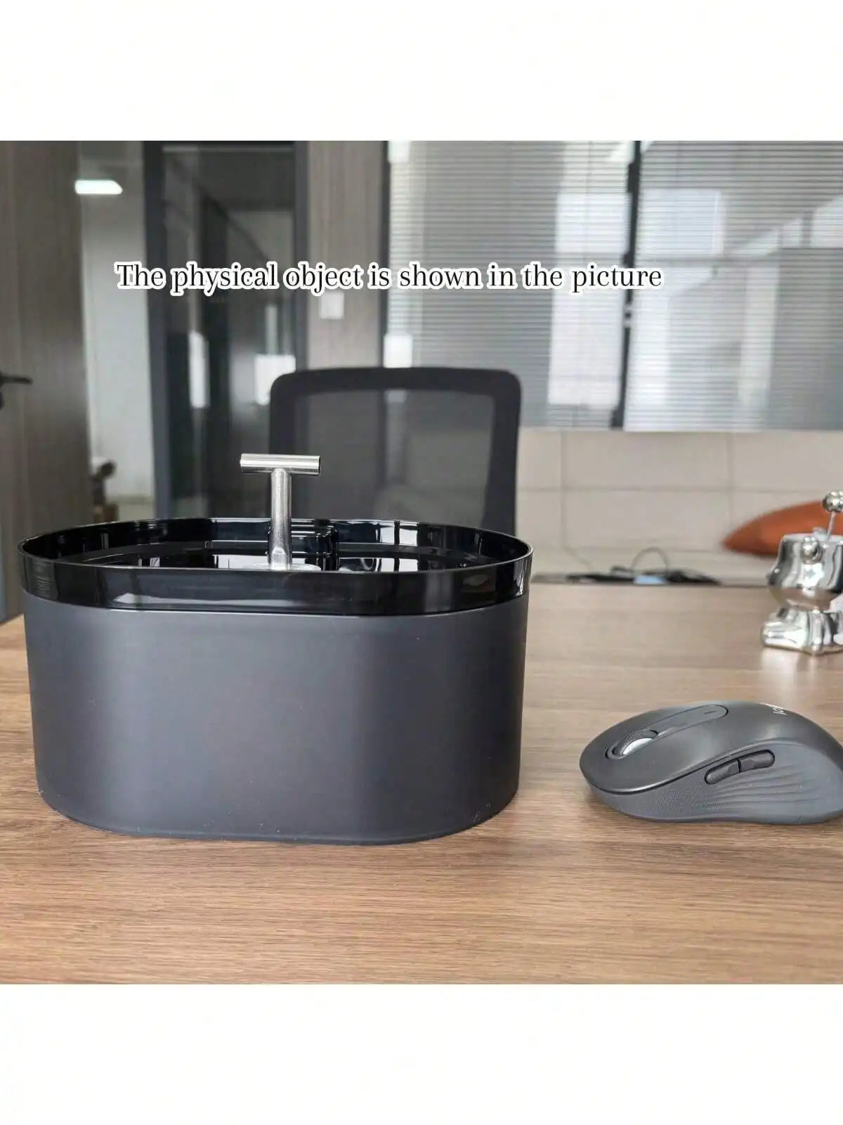 Un bol de fontaine à eau automatique pour chat gris foncé sur une table en bois.