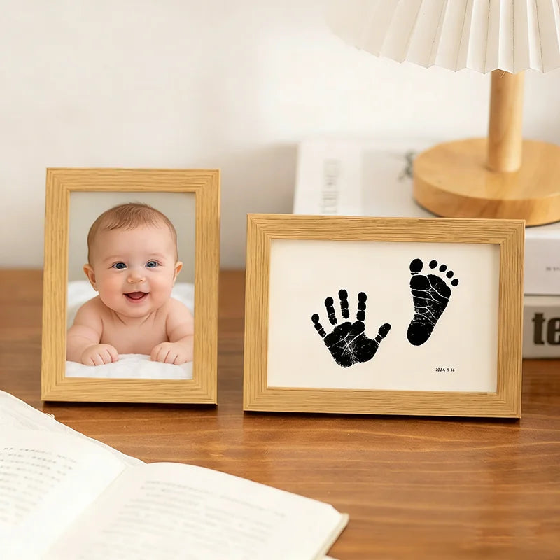 A wooden photo frame displays a baby's face and a pet paw print, used as a keepsake kit.