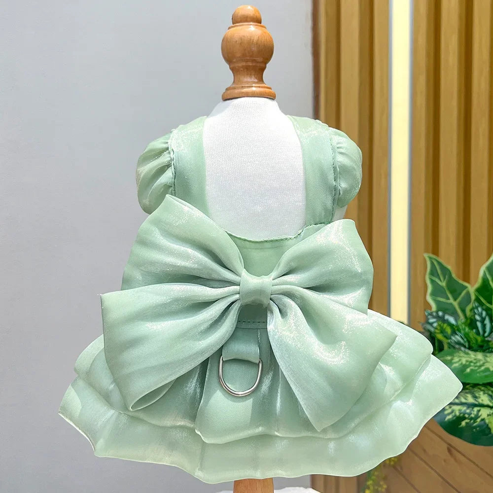 A light mint green pet dress with a large bow and D-ring attached, displayed on a mannequin.