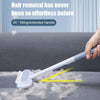 A hand is using a white pet hair remover brush with an extended handle to remove pet hair from a gray surface.
