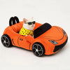 An orange supercar shaped cat bed with black accents and a white cat wearing sunglasses resting on the cushion.