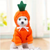 Un perro blanco pequeño vistiendo una sudadera con forma de fruta naranja, top verde y lazo blanco.