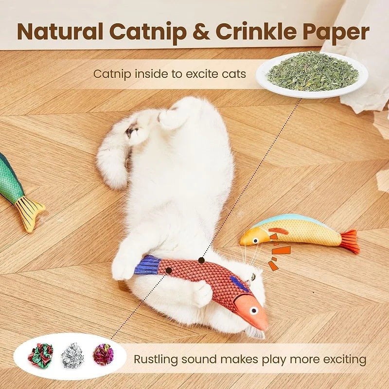 A white cat plays with a textured green catnip fish plush toy on a wooden floor.