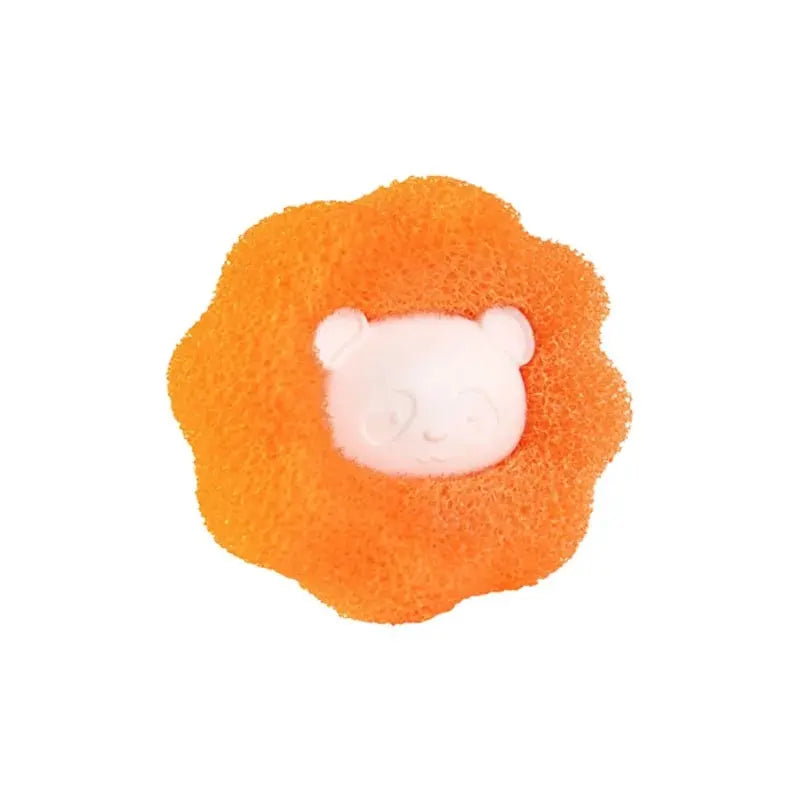 An orange, porous ball with a white, round face resembling a bear, used for pet hair and lint removal.