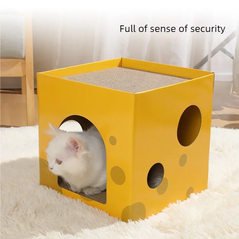 A yellow cardboard cat scratching house with a textured entrance and several circular holes, placed on a white fluffy surface