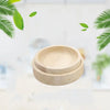 A stack of smooth wooden feeding bowls for small pets with green leaves in the background.
